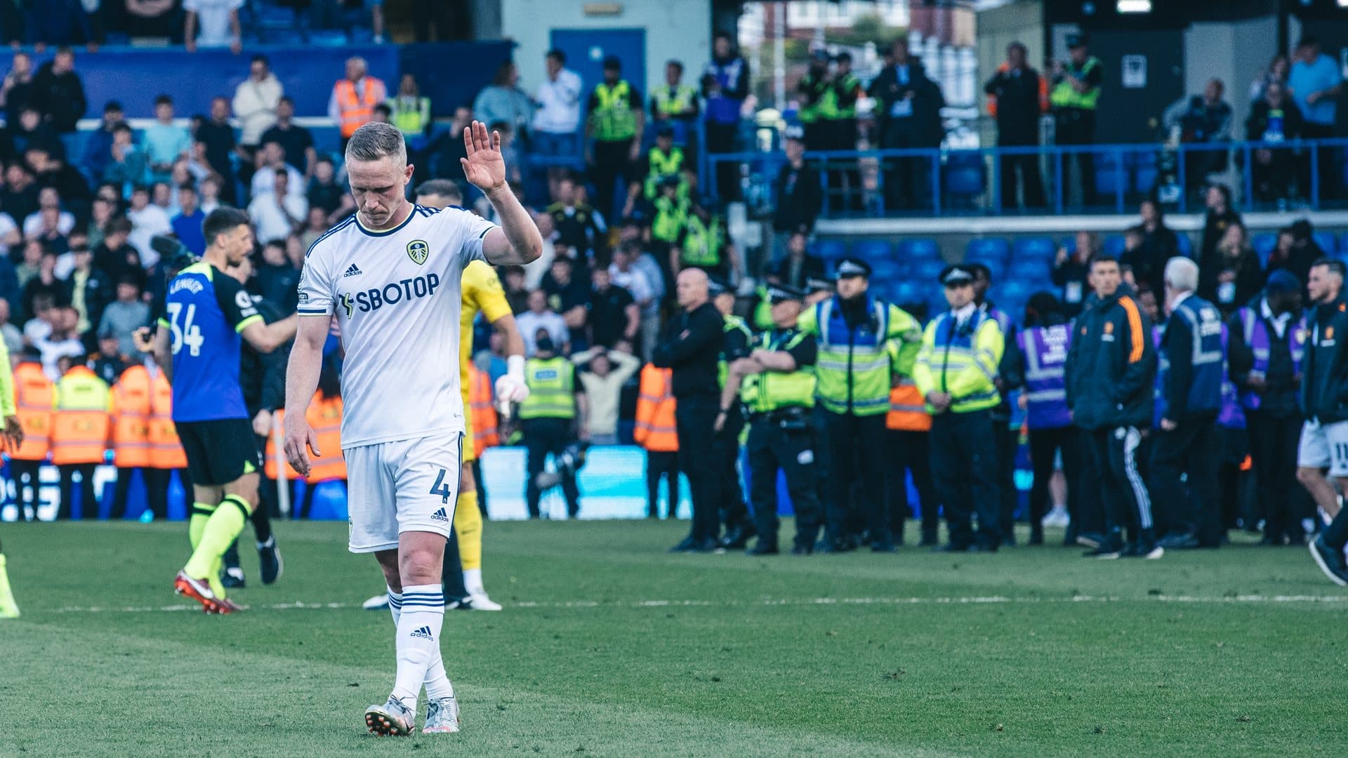 Adam Forshaw, looking dejected, holding his hand up to the crowd at the end of the final game against Spurs
