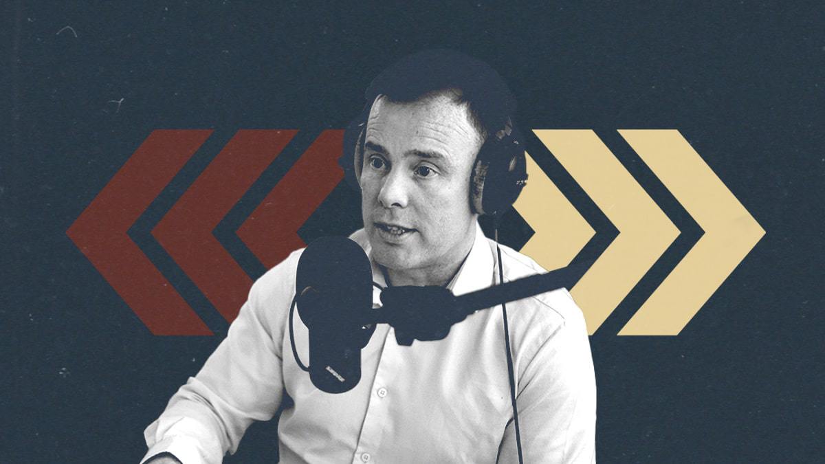 A picture of Angus Kinnear with headphones on, behind a microphone, against a backdrop of arrows representing player movements