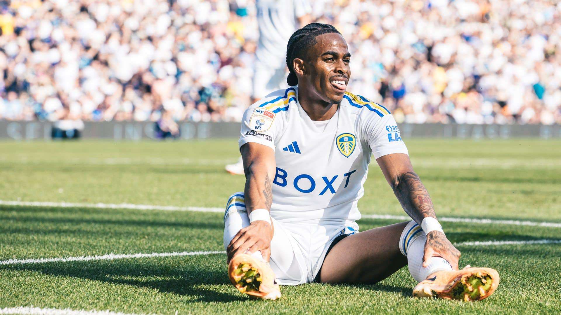 Crysencio Summerville sitting on the ground in the penalty area after his effort is saved. He's got his tongue out as if he's going BLAH