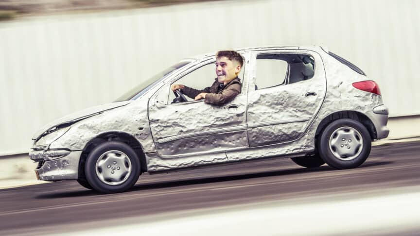 A photoshop of Dan James driving a battered old Peugeot, and looking absolutely delighted about it