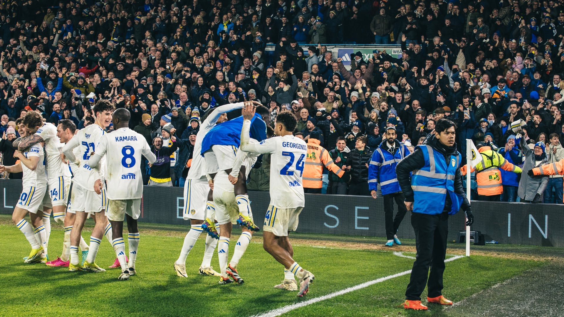 A crowd of Leeds players in the north-west corner of Elland Road, celebrating the third goal