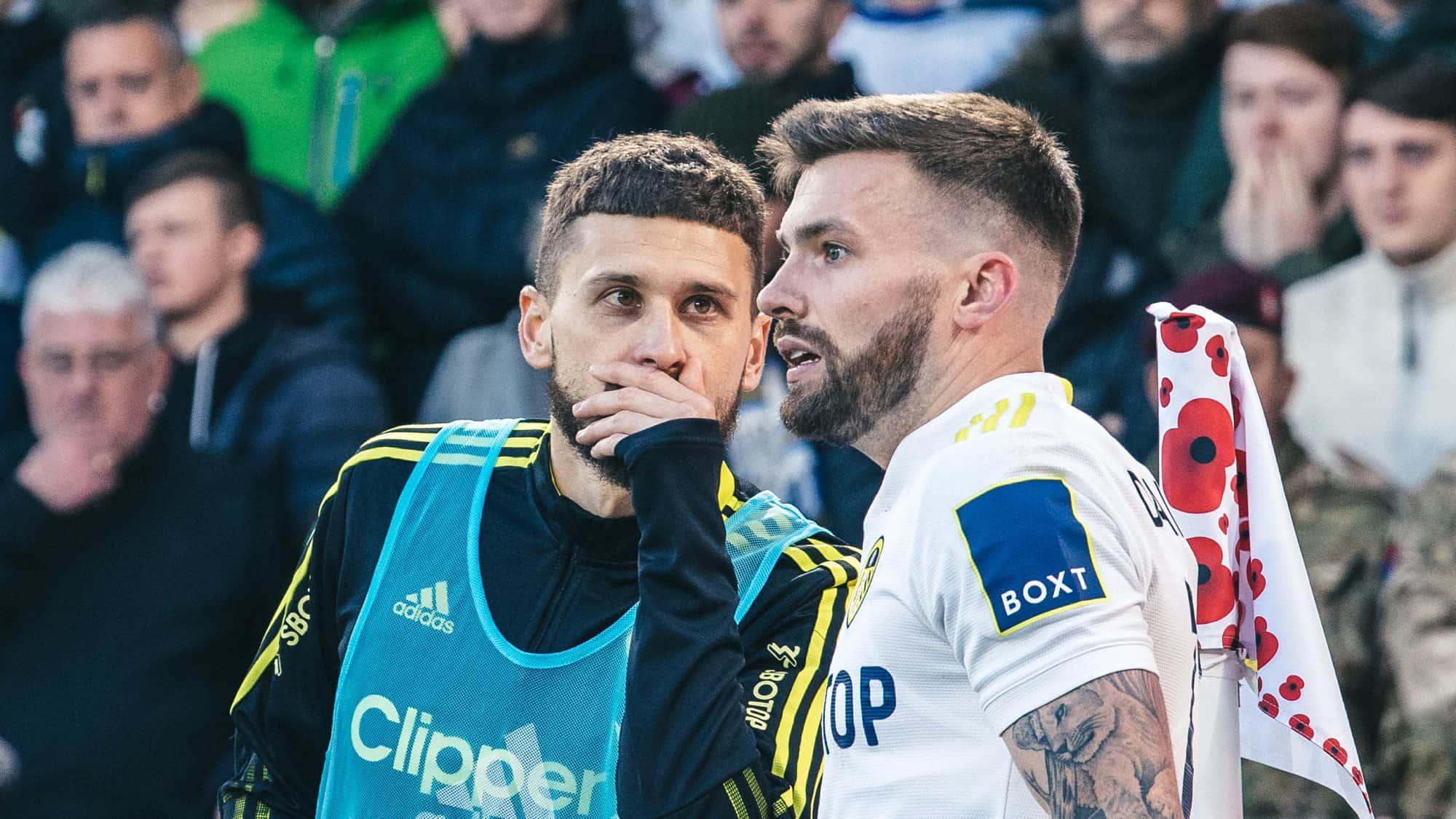 Stuart Dallas is going to take a Leeds corner against Leicester, in the north-west corner. Mateusz Klich is warming up in a subs' bib, but he's seen something, so he's whispering about it to Stuart