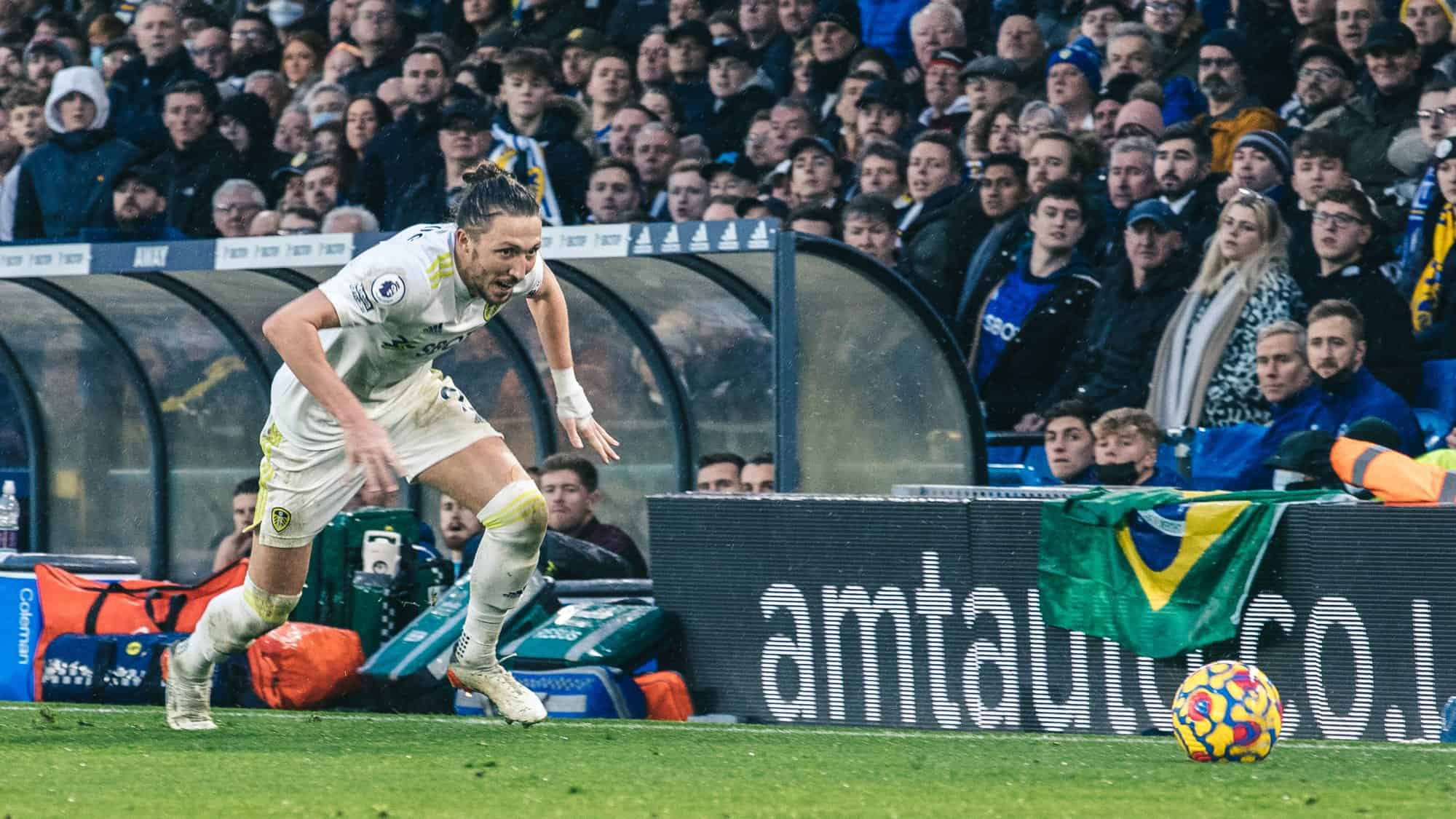 Luke Ayling chasing the ball, with a bandage on his left wrist, as if when he catches it he's going to punch it