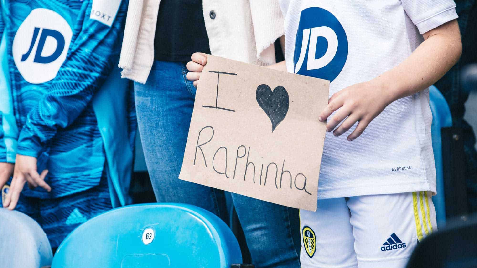 A kid holds a homemade I heart Raphinha sign at Elland Road