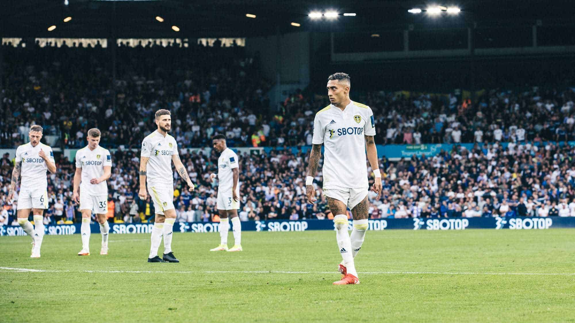Raphinha looks absolutely fuming while a bunch of other Leeds players stand in the background, including Klich, who just missed that massive chance