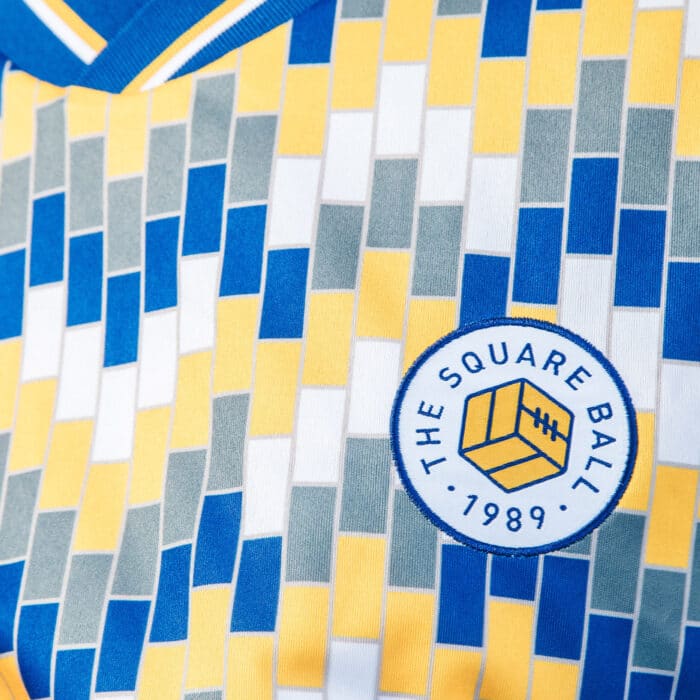 A close up of The Square Ball x Admiral 2023/24 Lowfields shirt, featuring a blue, yellow and white tiled pattern to replicate the walls of the Lowfields tunnel