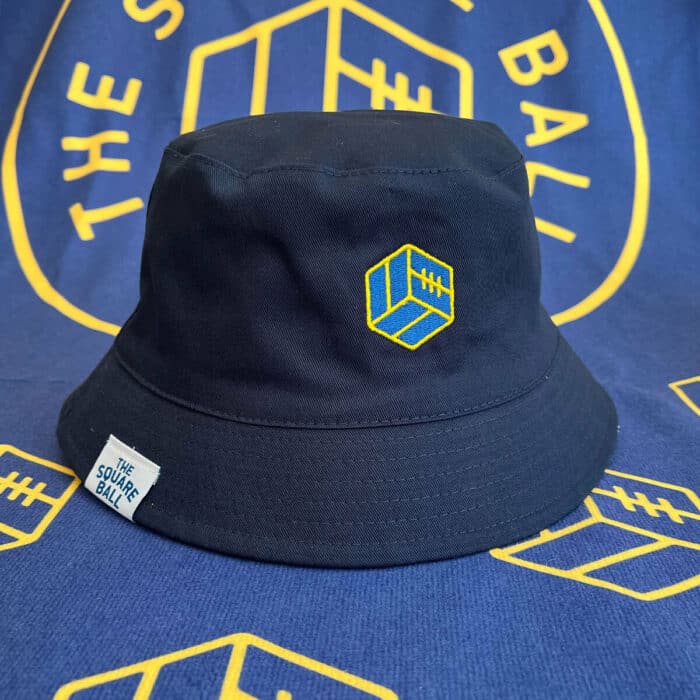 The blue side of our reversible TSB bucket hat, with a yellow and blue embroidered TSB icon logo