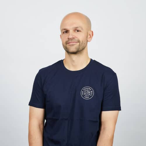 Our Michael wearing a navy t-shirt with a small round TSB logo on the chest in white