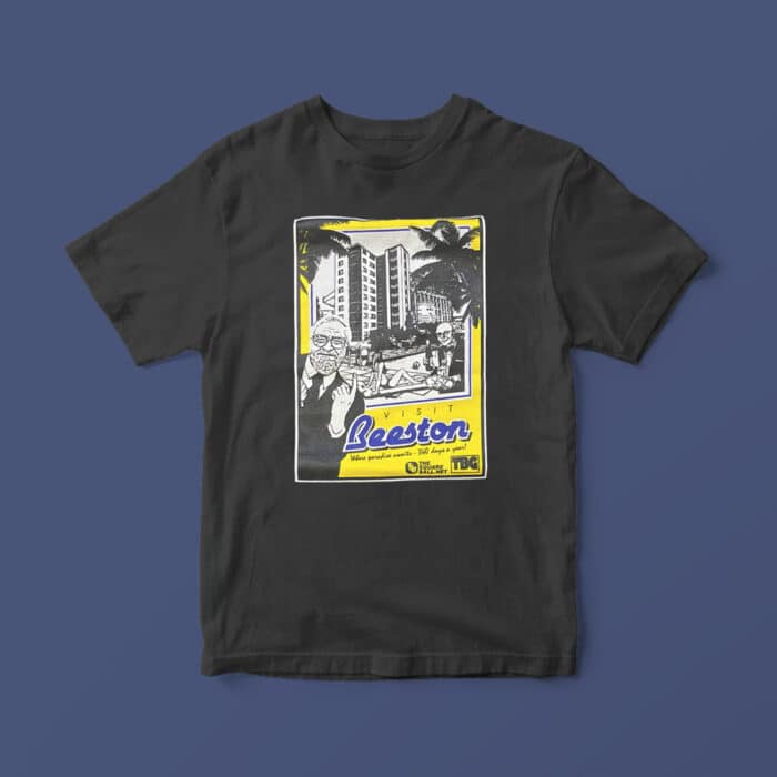 Photo of a black t-shirt with TSB's Visit Beeston artwork on the front, featuring a drawing of Ken Bates beckoning you into a new pool in front of Elland Road's East Stand, which is now obscured by a hotel