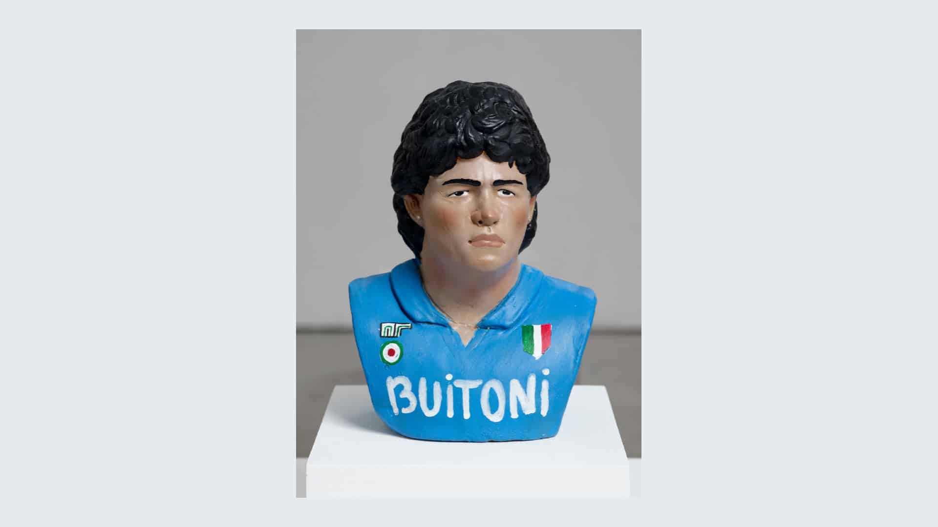 A photo of a Neapolitan Diego Maradona bust in a glass case
