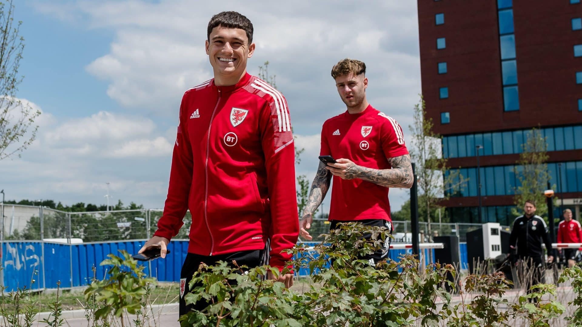 A photo of Dan James and Joe Rodon on a pre-game walkabout with Wales. Dan is nearest the camera with a massive grin on his face, perhaps because he knows the perspective on this photo will make him look taller than our new centre-half, who is in the background looking up squinting from his phone