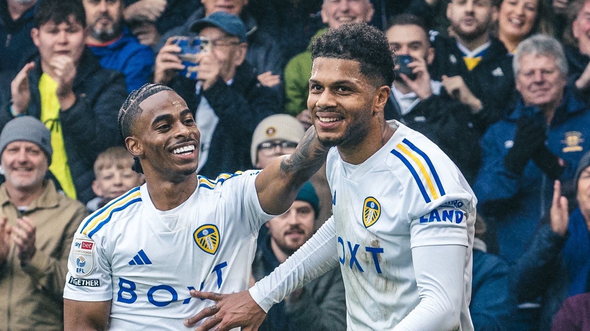 Crysencio Summerville merrily tweaking the ear of Georginio Rutter, in front of happy stands after the fourth goal against Huddersfield