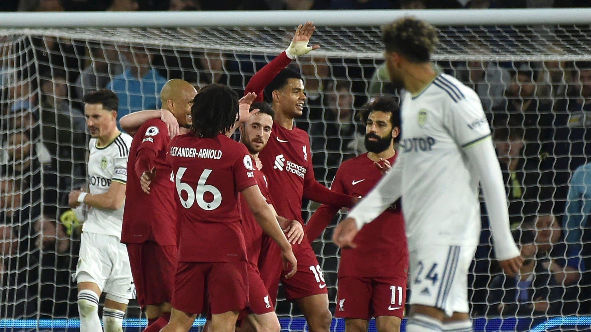 Georginio Rutter walks by in the foreground, looking back at Liverpool celebrating their, I dunno, fifth goal? sixth?