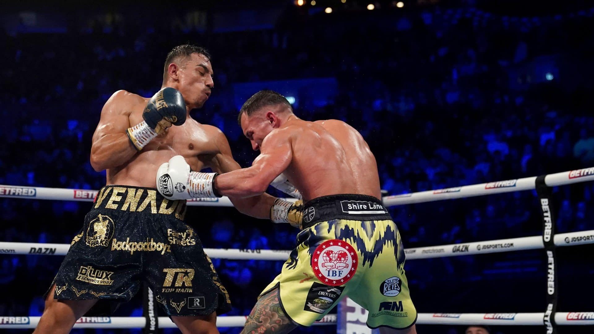 Luis Alberto Lopez and Josh Warrington fighting at Leeds Arena, each punching the other in the stomach at the same time, which is about how it went