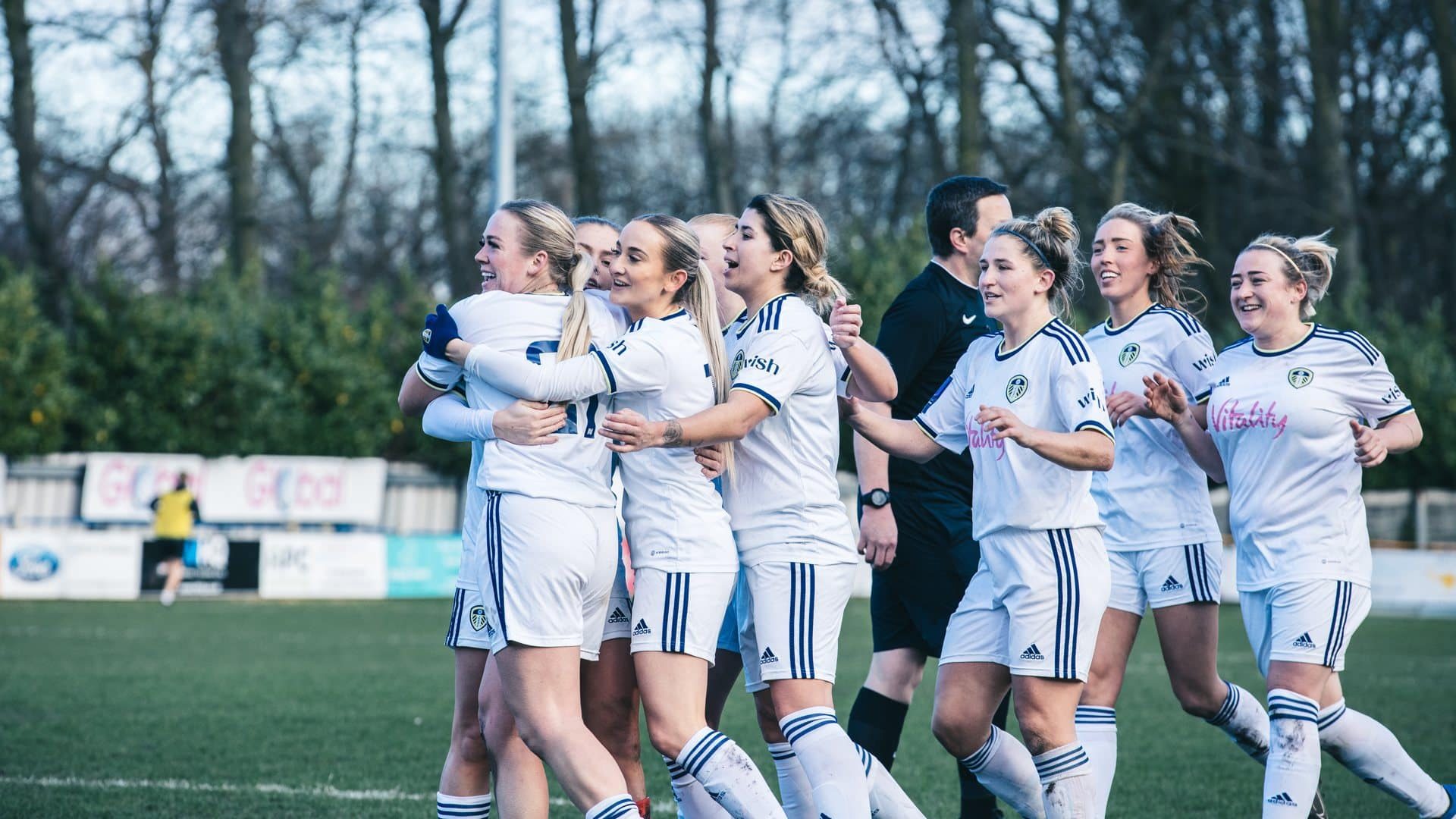 Amy Woodruff celebrating her second goal for Leeds against Southampton, with a full squad of teammates joining in