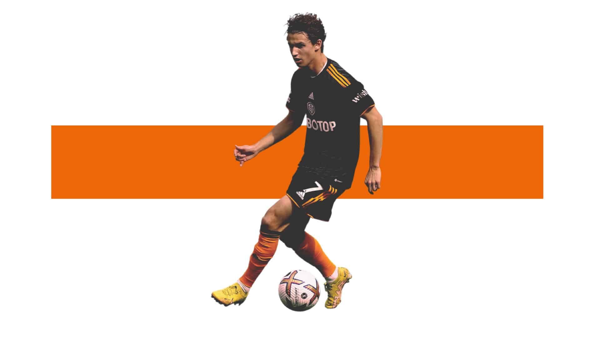 Brenden Aaronson playing in the black and orange away kit, against a white back drop with a horizontal orange bar running across