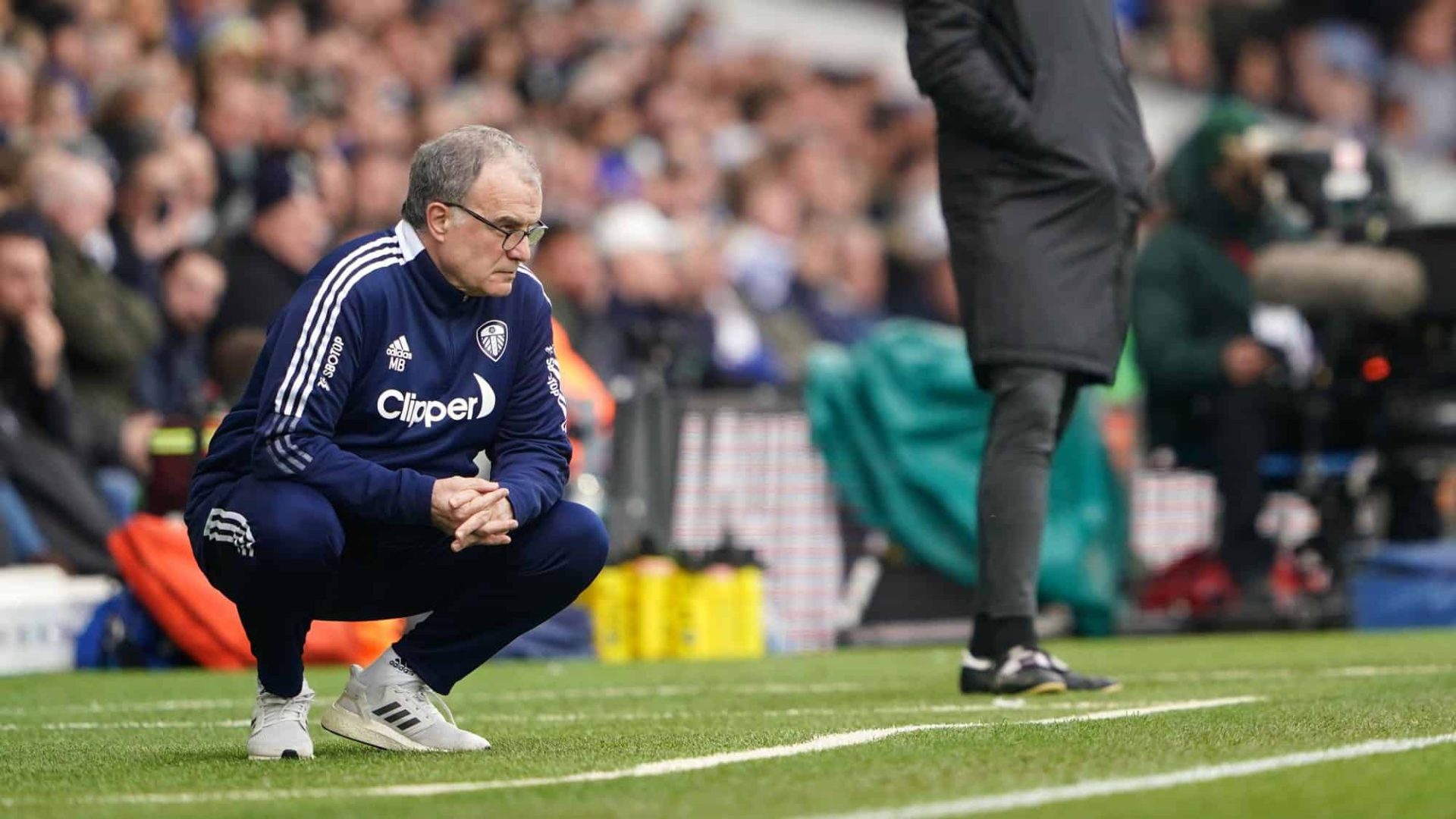 Marcelo Bielsa crouches in his technical area during Leeds' defeat to Spurs