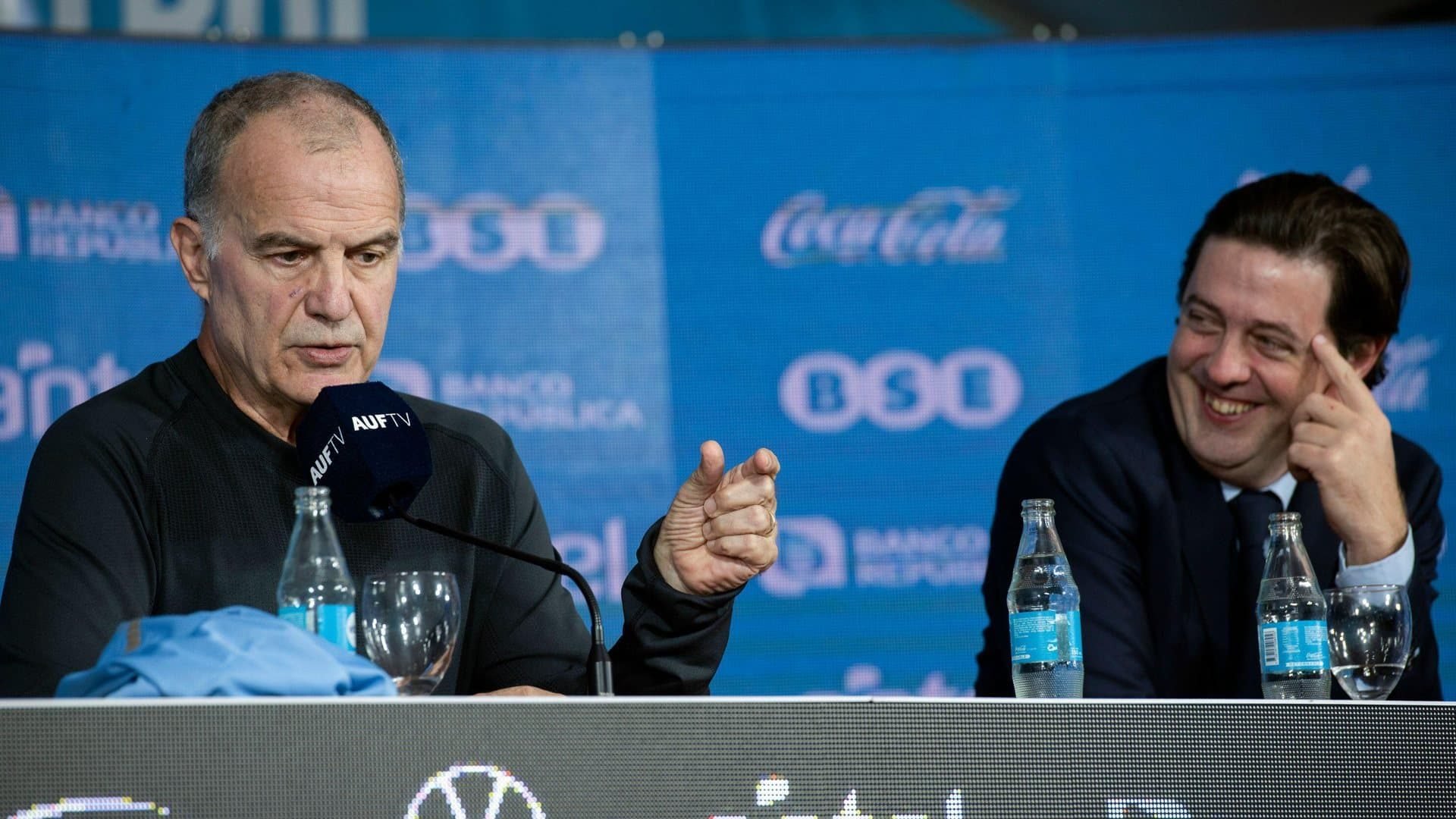 Marcelo Bielsa at his first press conference as manager of Uruguay, alongside Ignacio Alonso, head of the Uruguay Football Association, who is looking at him admiringly, as well he might