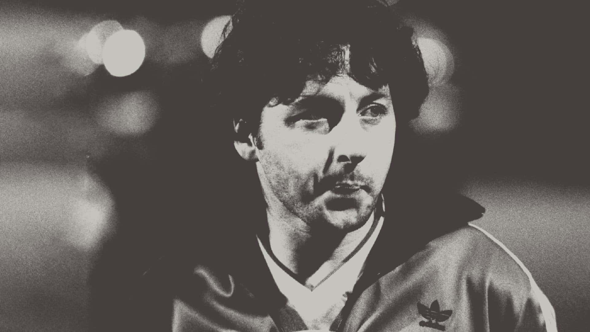 A black and white photo of Mickey Thomas in an Adidas tracksuit top looking ace