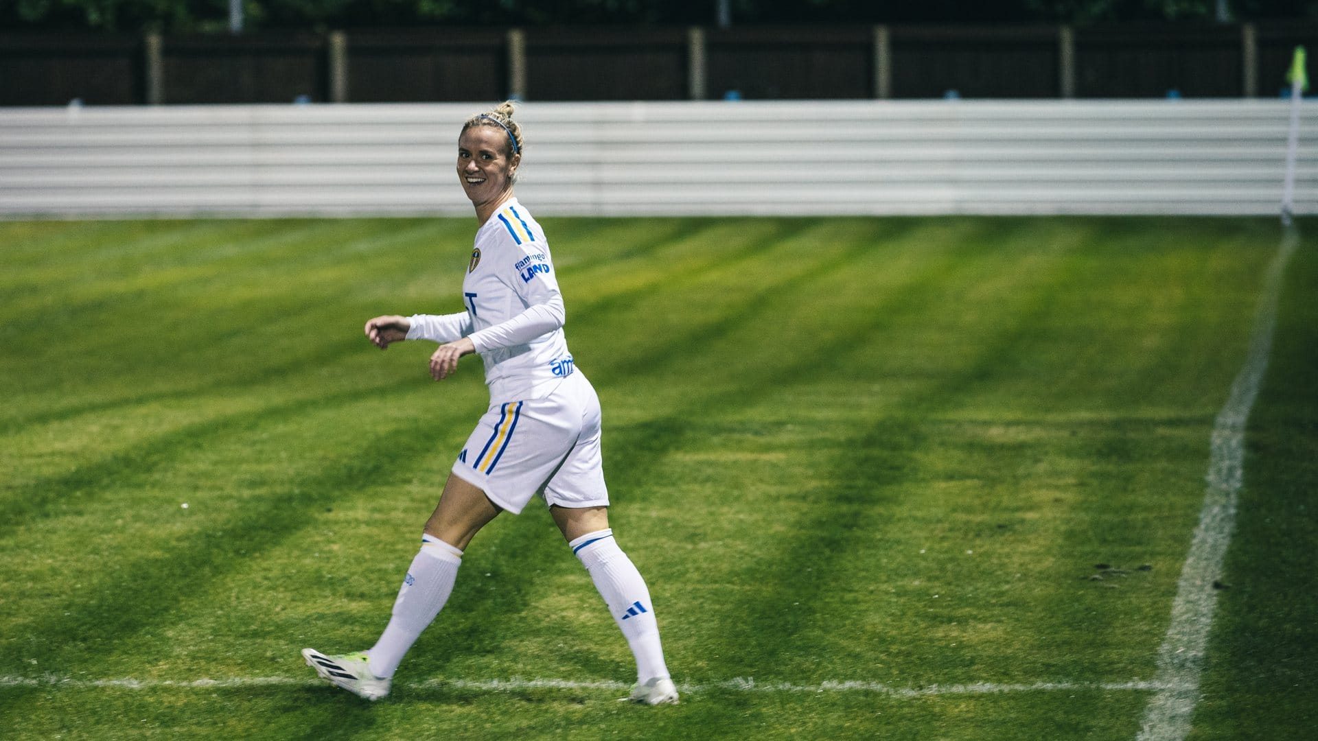 Olivia Smart of Leeds United Women striding onto the pitch at Garforth before playing FCUM, turning to the camera and laughing