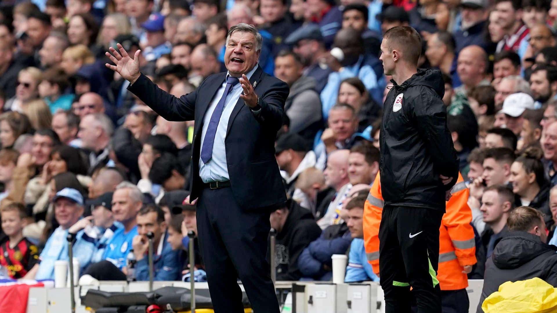 Sam Allardyce standing next to the fourth official at the Etihad, angry about something, holding his arms out as if trying to measure his anger
