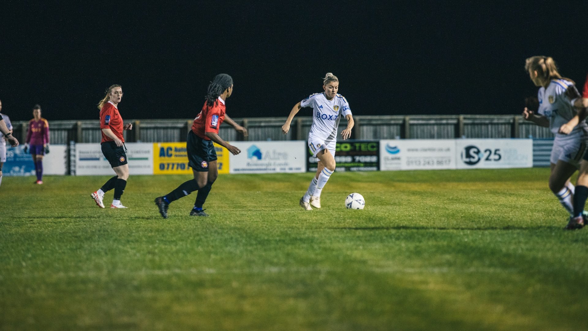 A photograph of Sarah Danby playing for Leeds United Women against some team in red