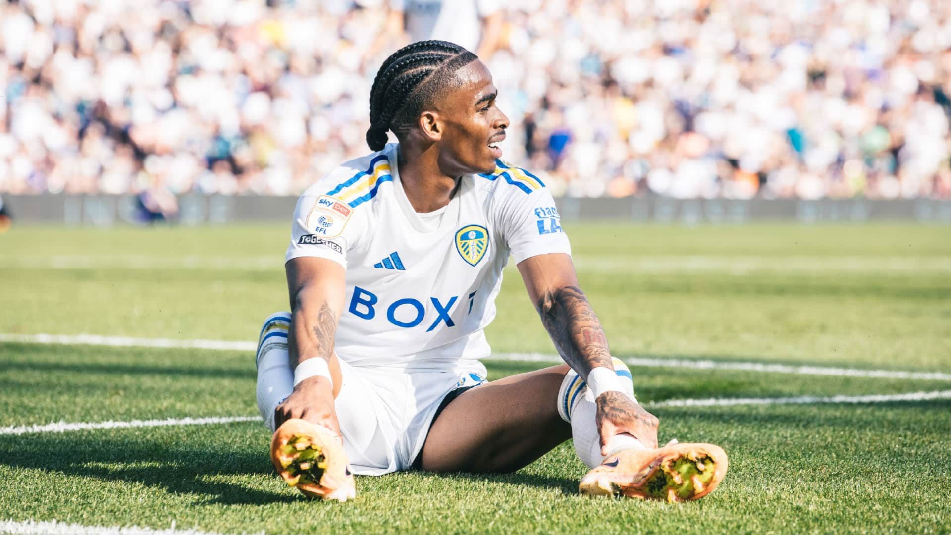 A photograph of Crysencio Summerville sitting on the pitch at Elland Road. He's not going on strike, just to be clear