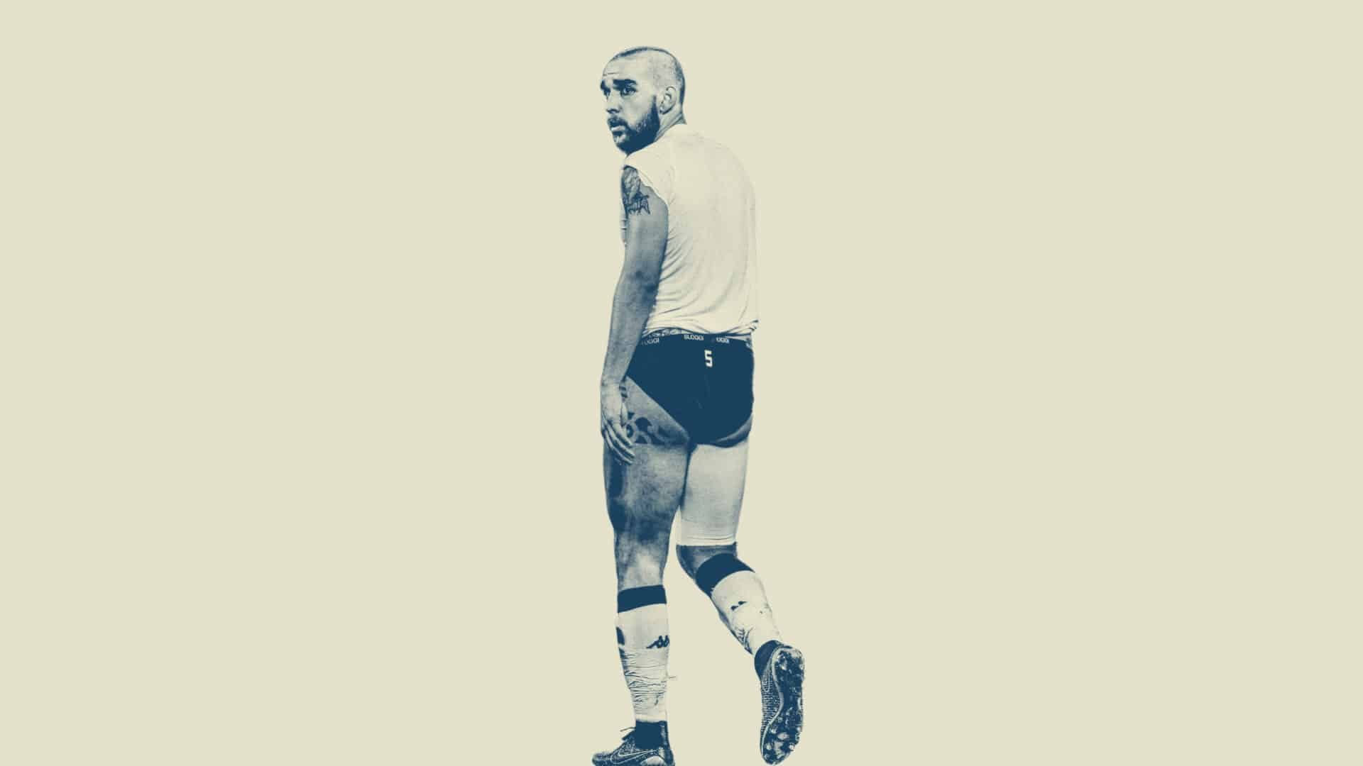 A black and white image of Giuseppe Bellusci at the end of a Leeds game, stripped down to a vest and his underpants. There's a number 5 printed on his arse. He's still got his socks and boots on.