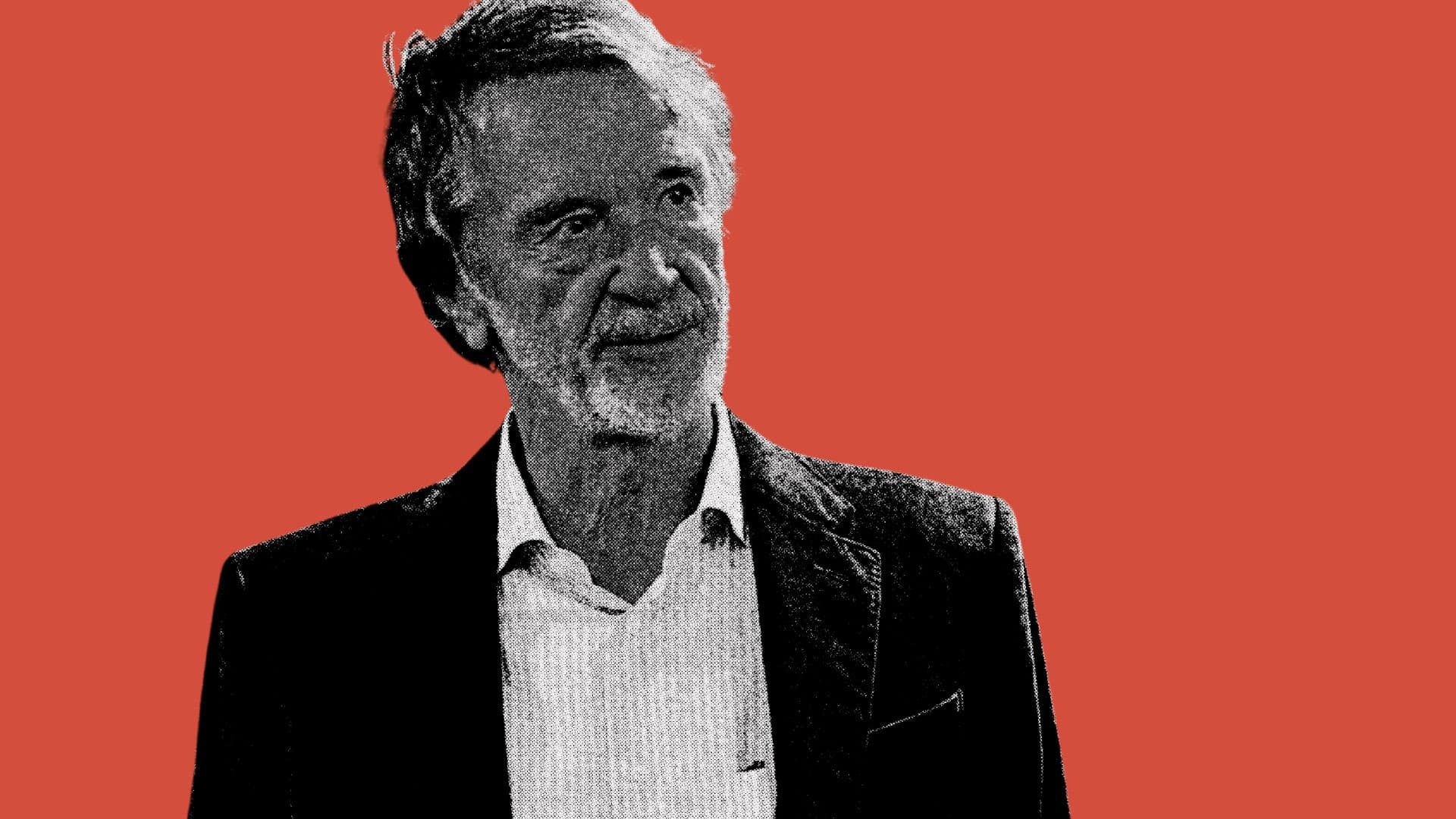 A black and white image of Jim Ratcliffe set against a red background. He looks gormless, as you would have to be to invest in Scum