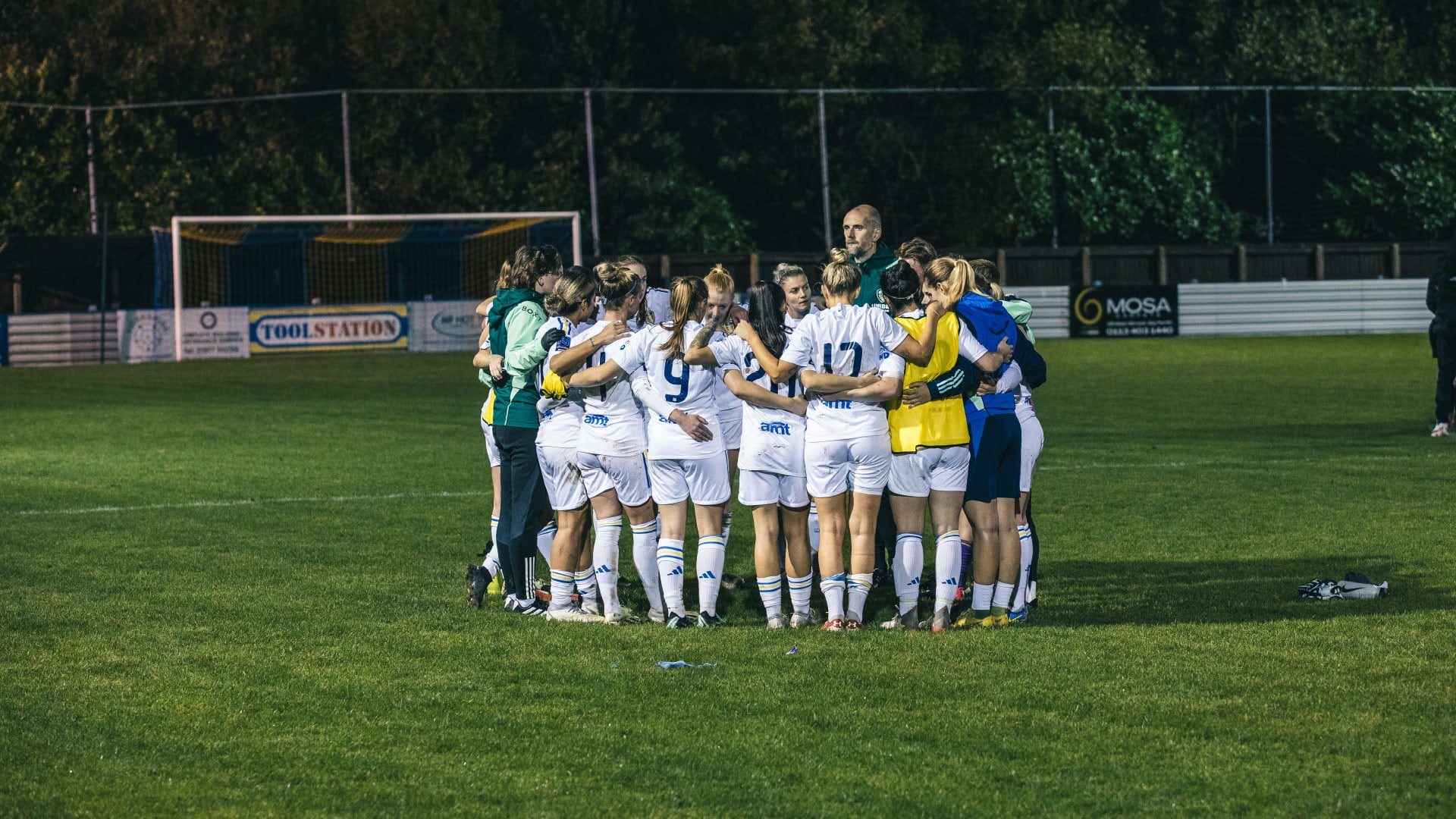 A photograph of Leeds United Women standing in a post-match huddle