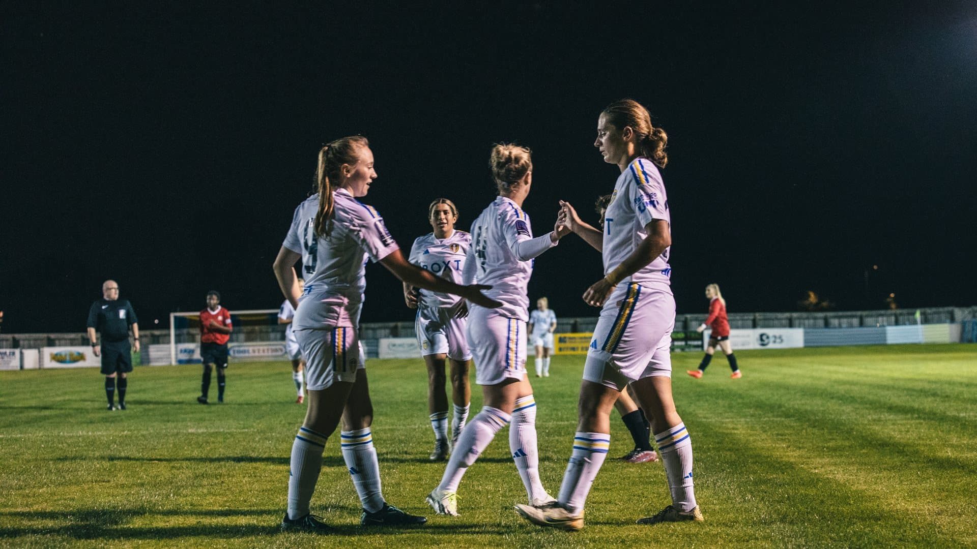 Lots of handshakes among Leeds United Women's players on a floodlit night when they beat FCUM earlier in the season