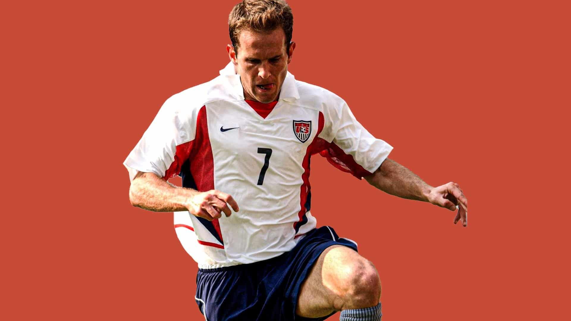 Eddie Lewis playing for the USMNT at the 2002 World Cup, against a red backdrop