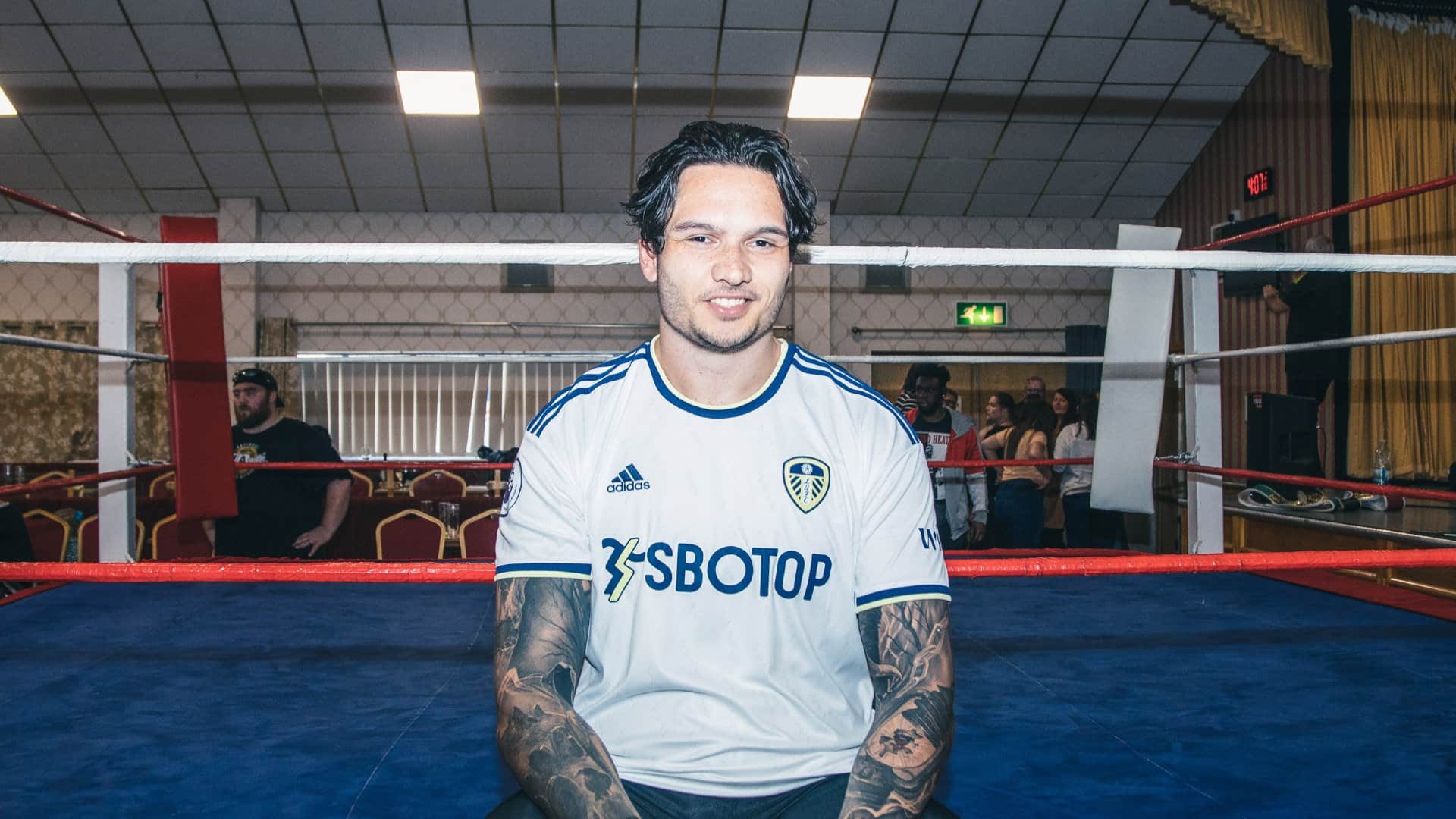 A photo of wrestler Joshua Kemper sitting on the ring apron wearing the 22-23 Leeds home shirt after the Battle of Belle Isle