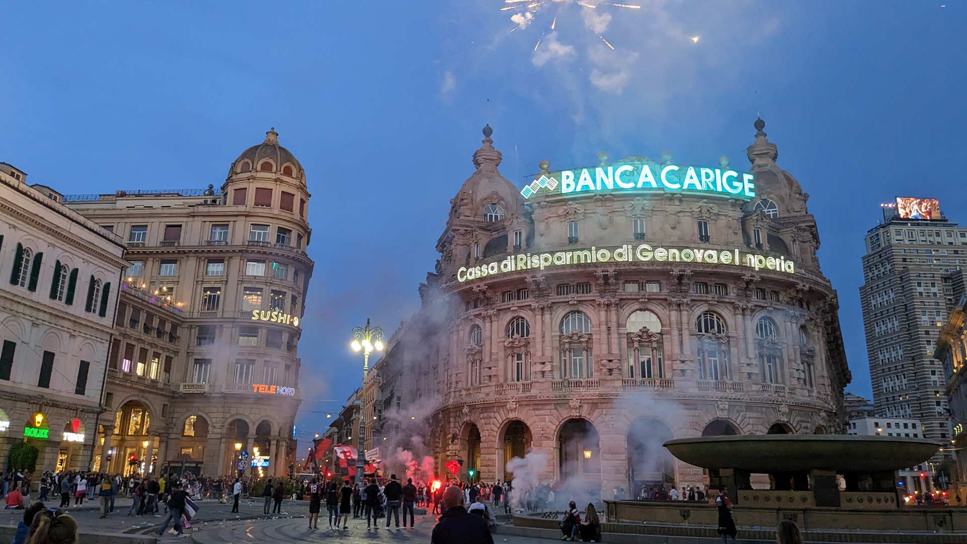 A photo of a town squad in Genoa, with smoke from flares filling the air and fireworks in the sky